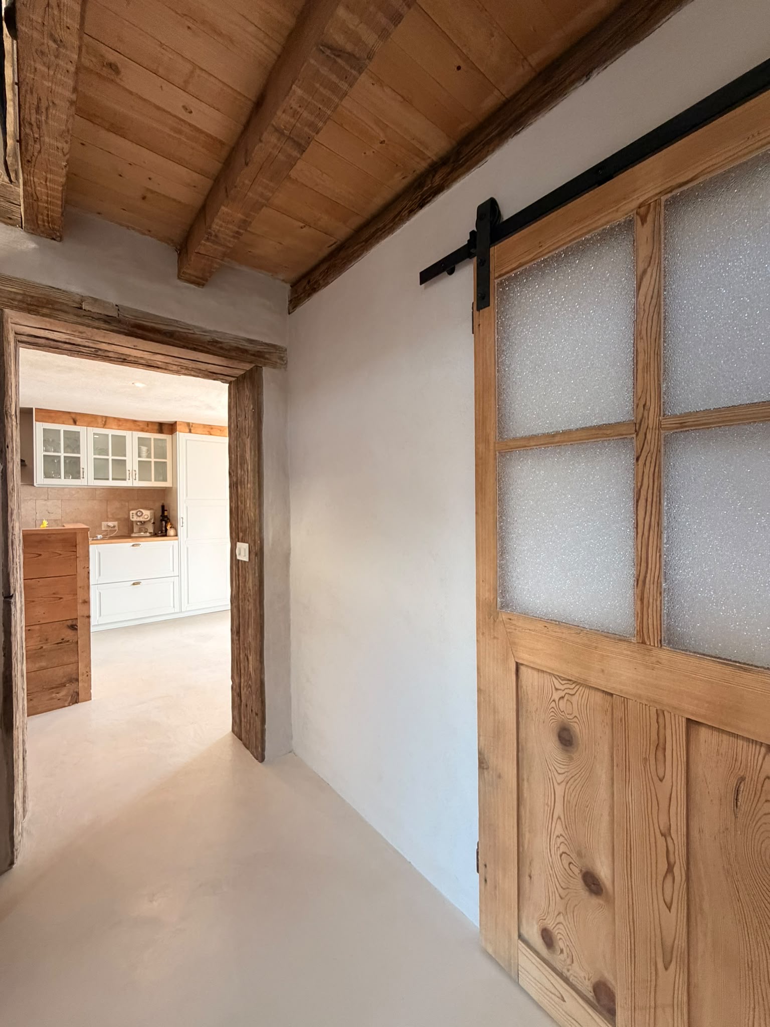 Porte coulissante en bois, enduits clairs et sol continu