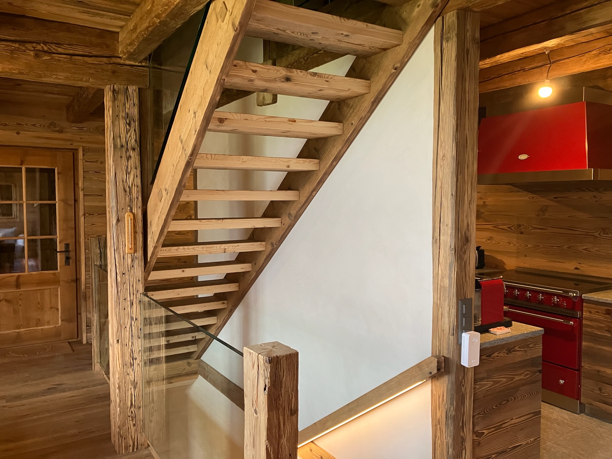 Escalier en vieux bois et cloison enduite dans un chalet rénové