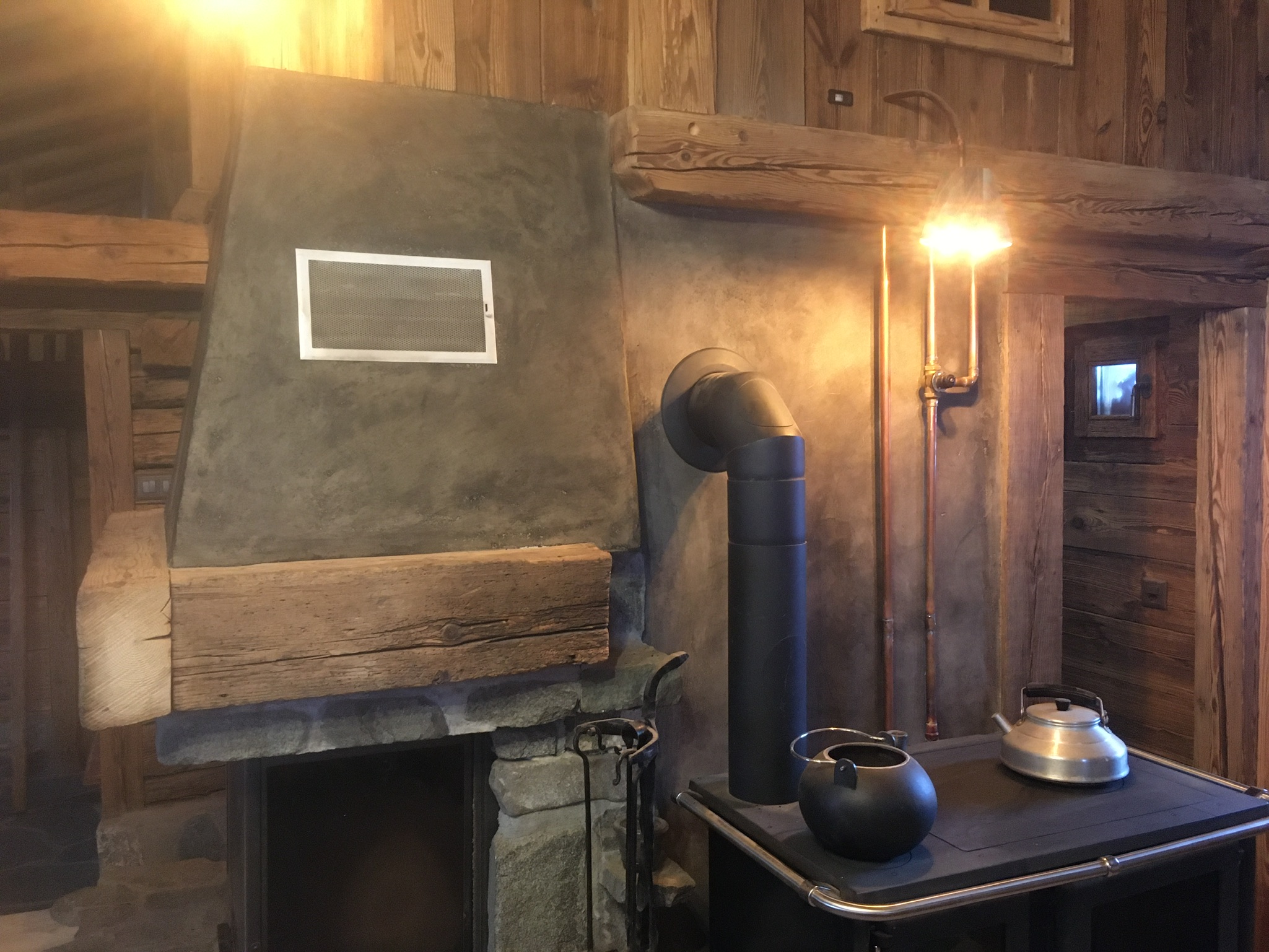 Hotte de cheminée enduite à la chaux et poêle à bois